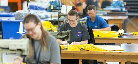 Kinectrics workers sewing together protective suits.
