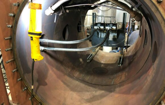 Illuminated interior of a large pipe mounted with testing equipment