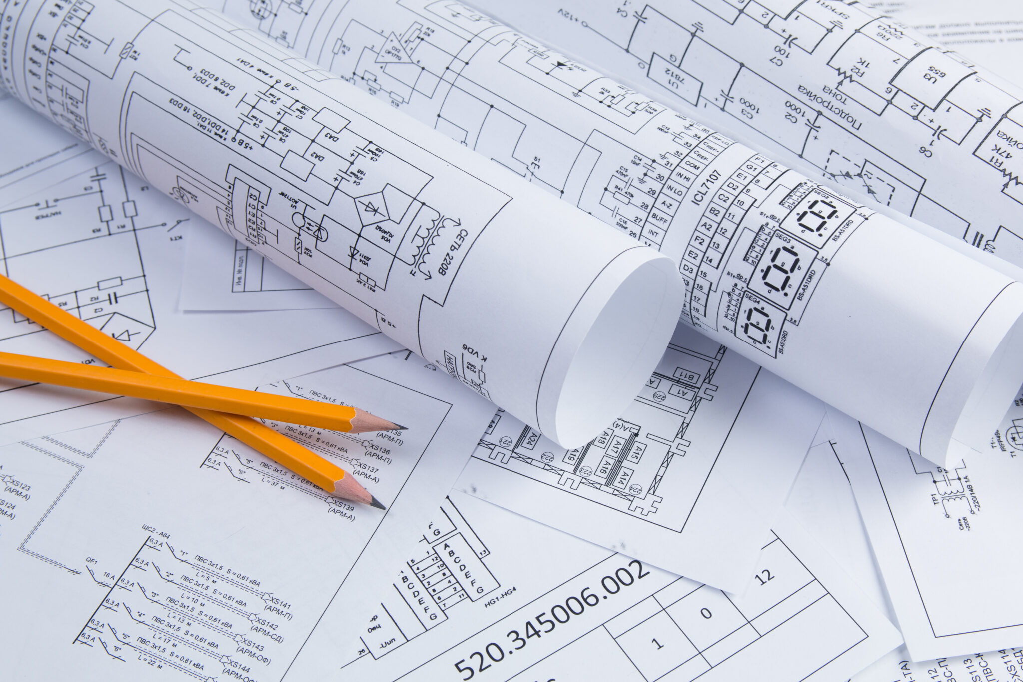 Rolls of electrical design layouts on a desk.