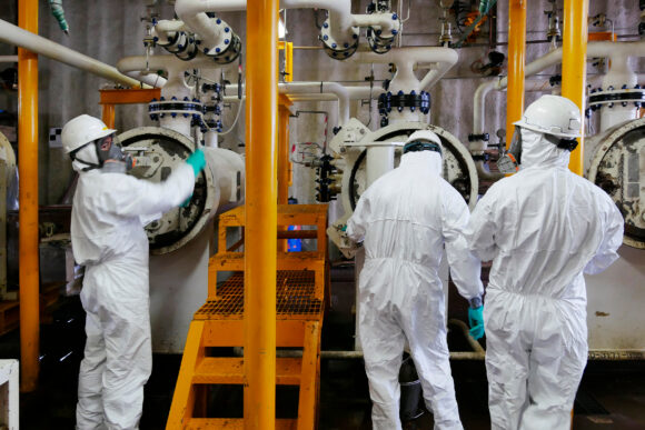 Industrial workers in Tyvek protection working at an industrial facility.