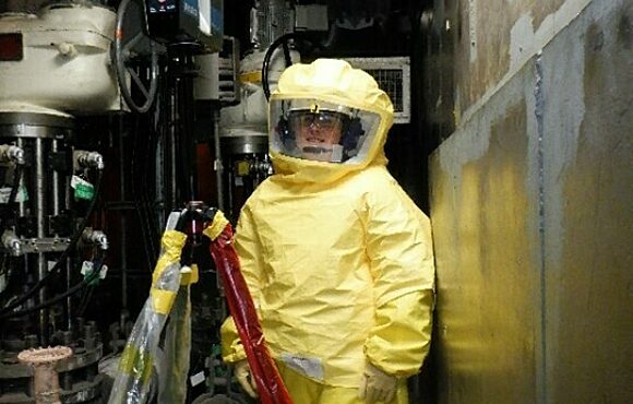 Worker in a plastic suit worker in a contaminated area of a nuclear reactor