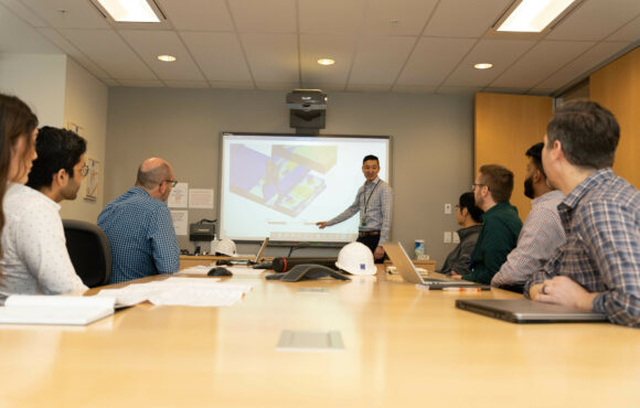 Worker presenting to a boardroom full of people