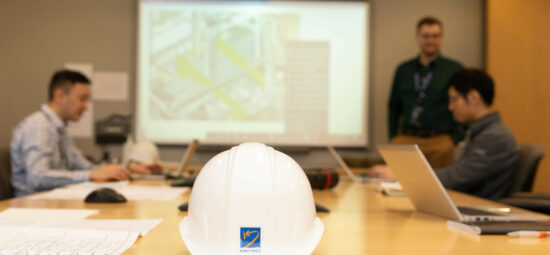 Hardhat with Kinectrics logo on table in boardroom