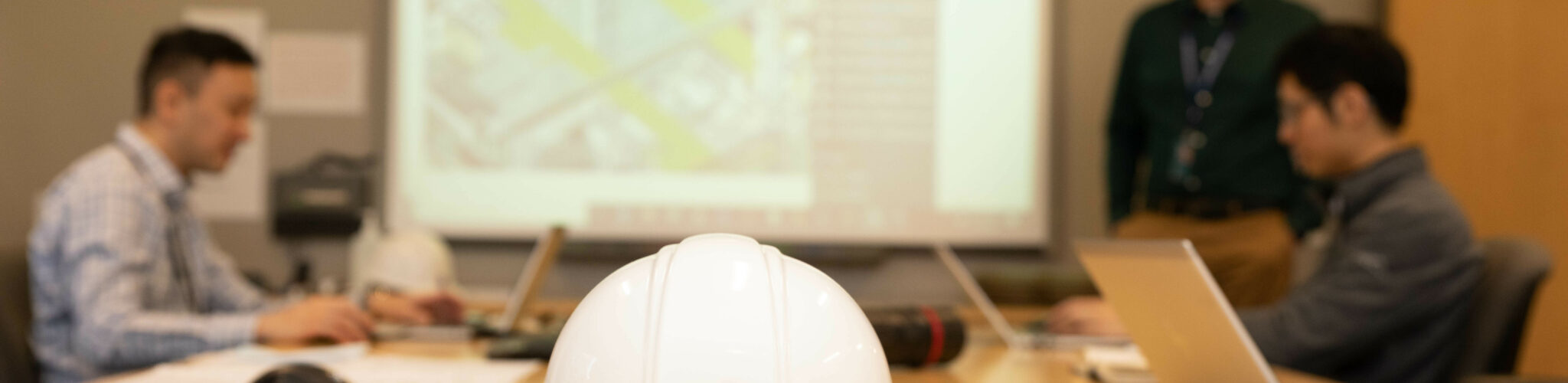 Hardhat with Kinectrics logo on table in boardroom