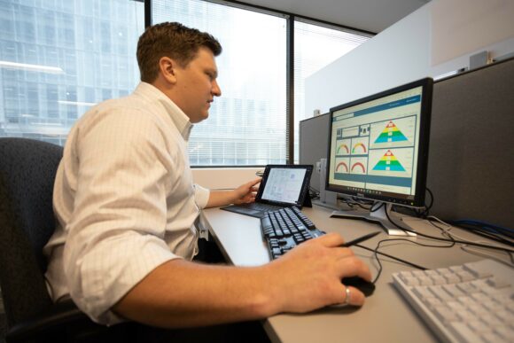 Worker organizing charts on a computer monitor
