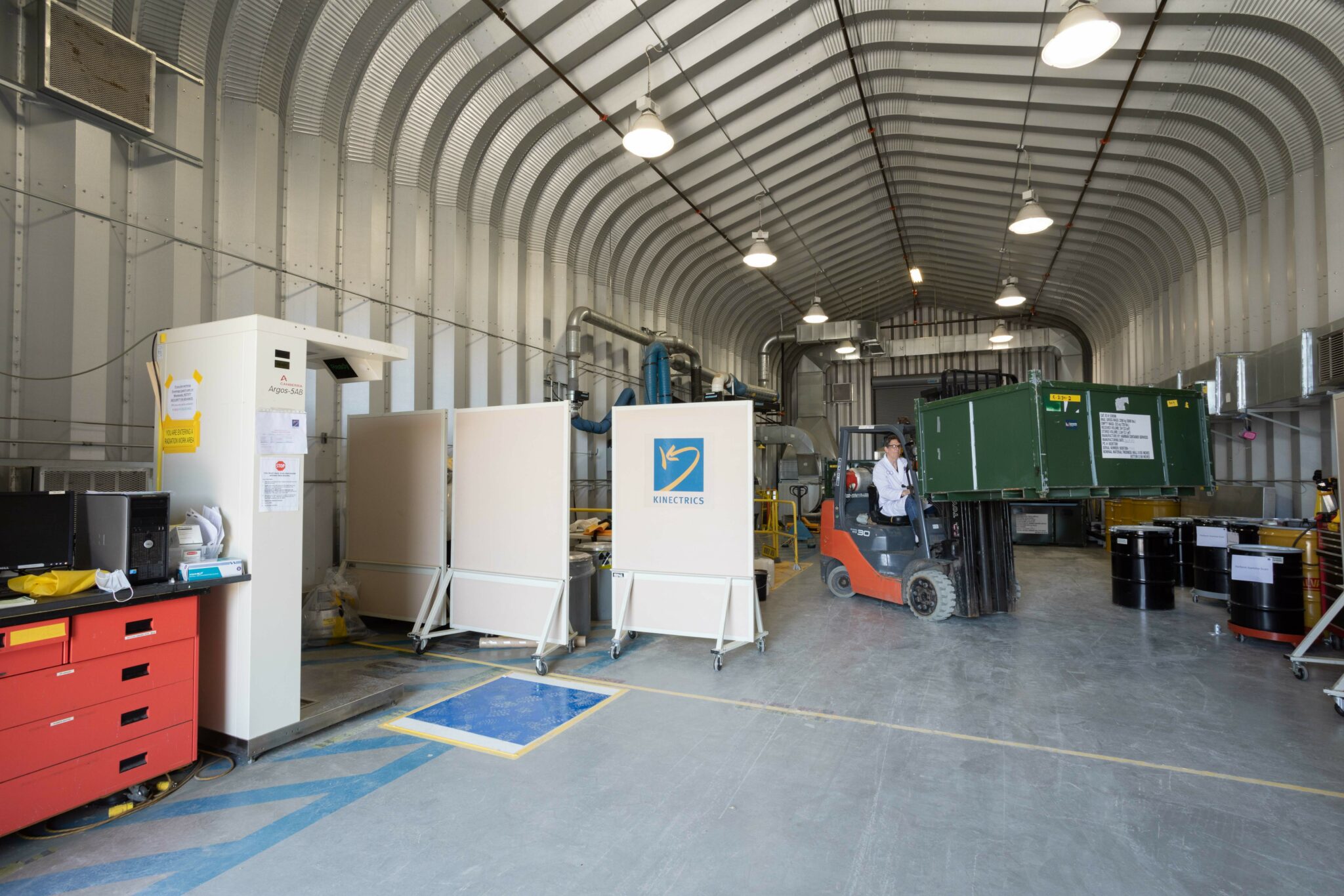 A worker operating a forklift inside a large licensed facility
