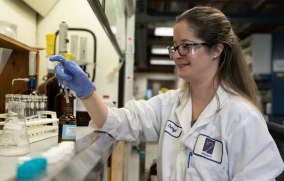 Worker performing chemical analysis in Kinectrics facility
