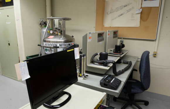 Computer station desk next to corrosion testing equipment
