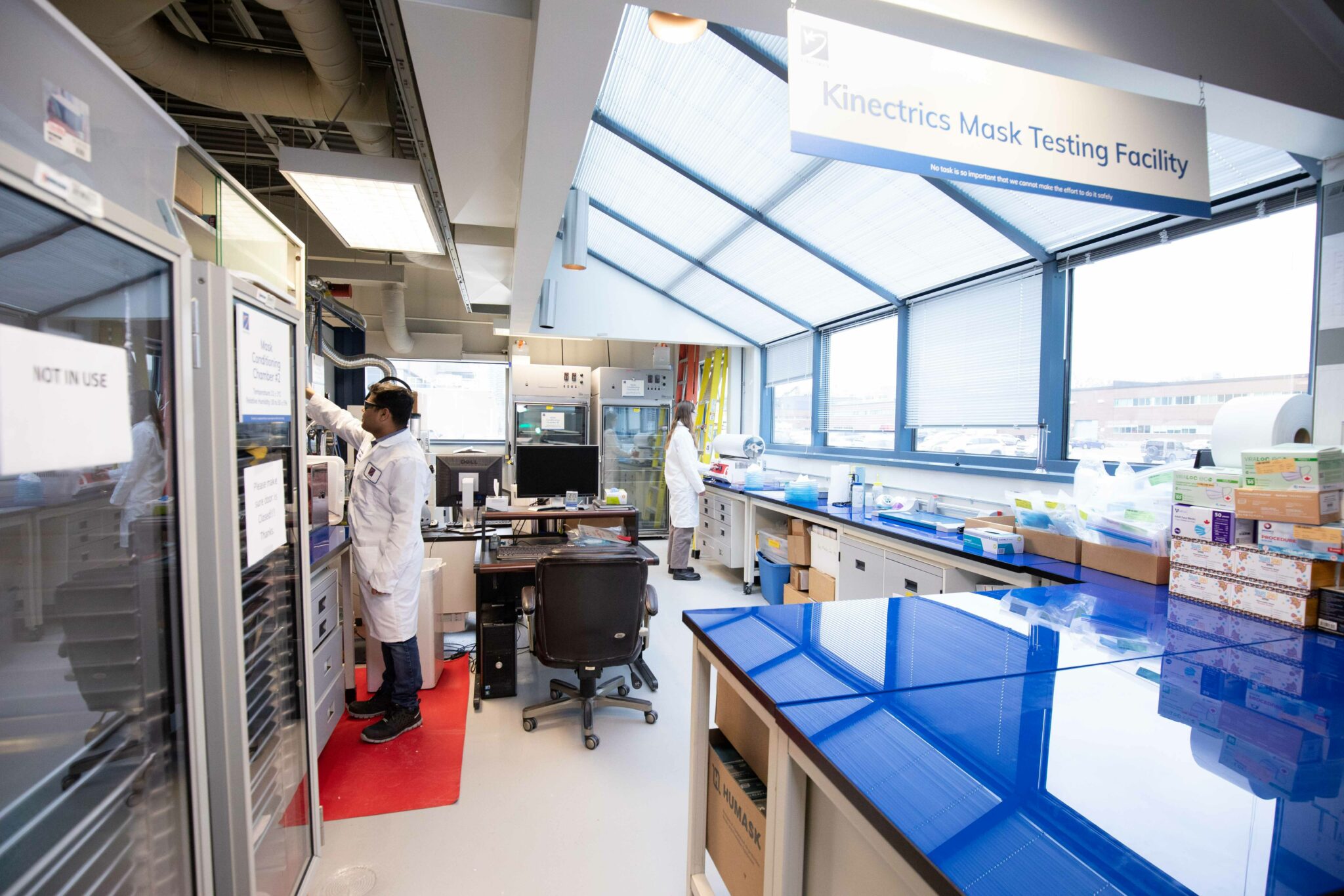 Workers performing tests in Kinectrics' mask testing facility