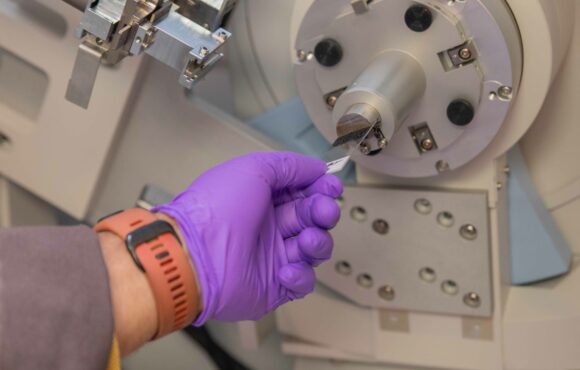 Worker inserting sample into large analysis machine