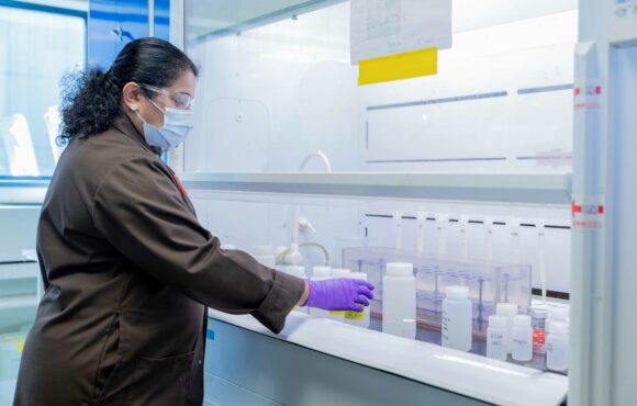 Chemist working with samples under laboratory fume hood