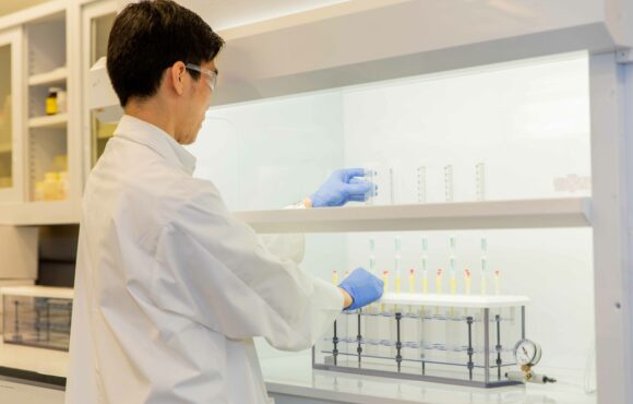 Worker examining test tubes filled with liquid