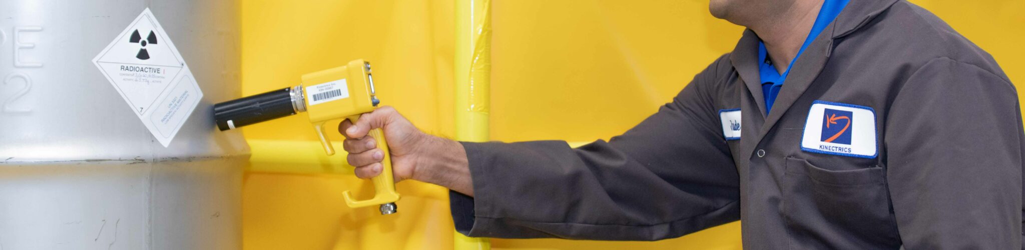 Radiation technician scanning a container filled with radioactive waste material