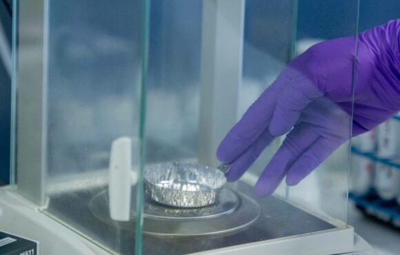 Closeup photograph of worker measuring a sample on an electronic scale