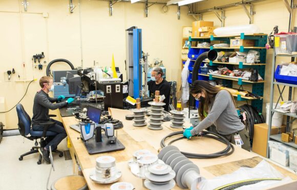 Workers preparing parts and electrical components for examination