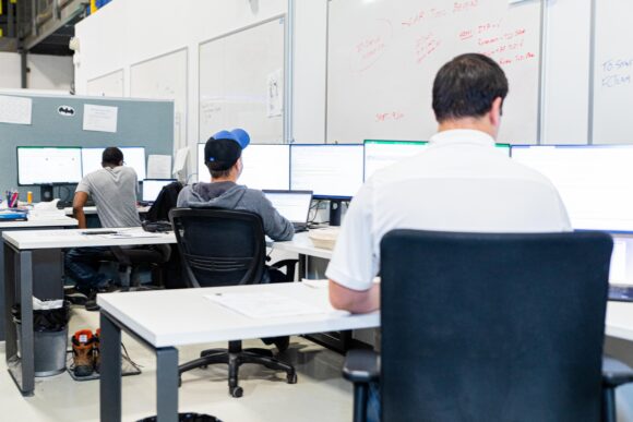 An office full of engineers working at their computer screens
