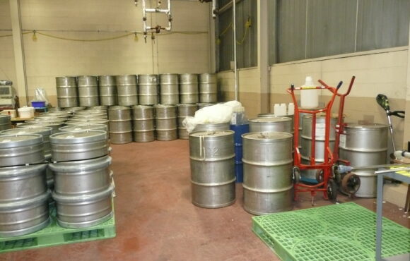 Photograph of dozens of storage drums in a handling area