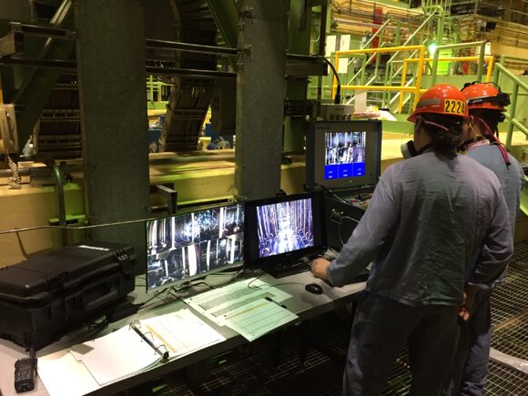 Industrial workers monitoring a feeder inspection system on location