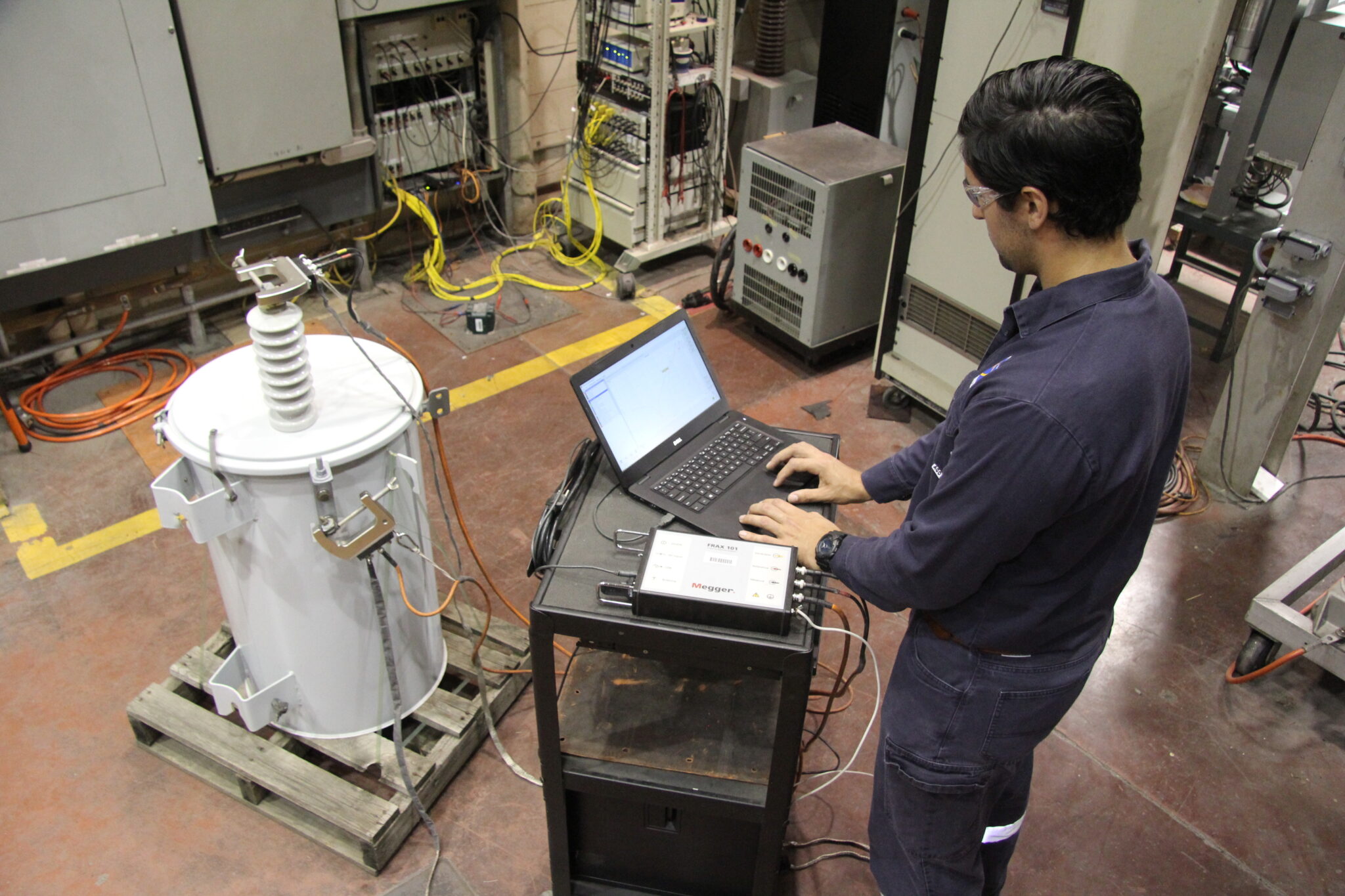 Technologist performing SFRA test on a polemount transformer after short circuit test in high current lab of kinectrics
