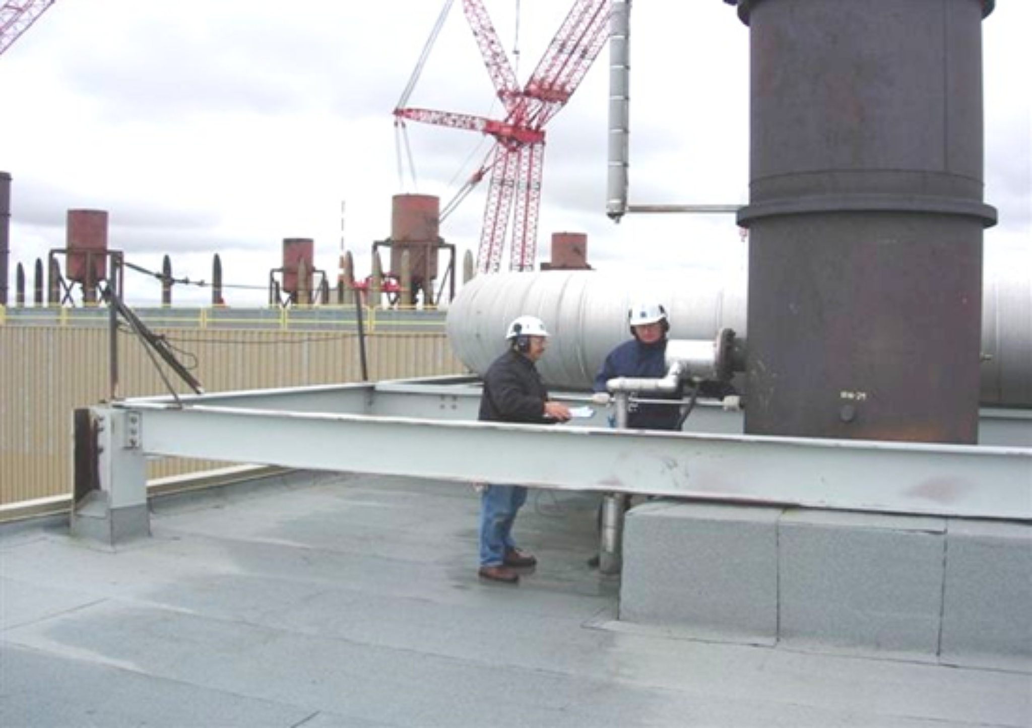 Workers on rooftop inspecting a stack